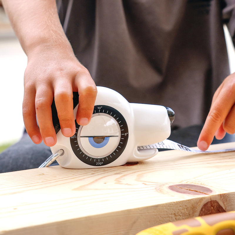Child measuring a wood board with a HandyFamm 4-in-1 kids dog tape measure