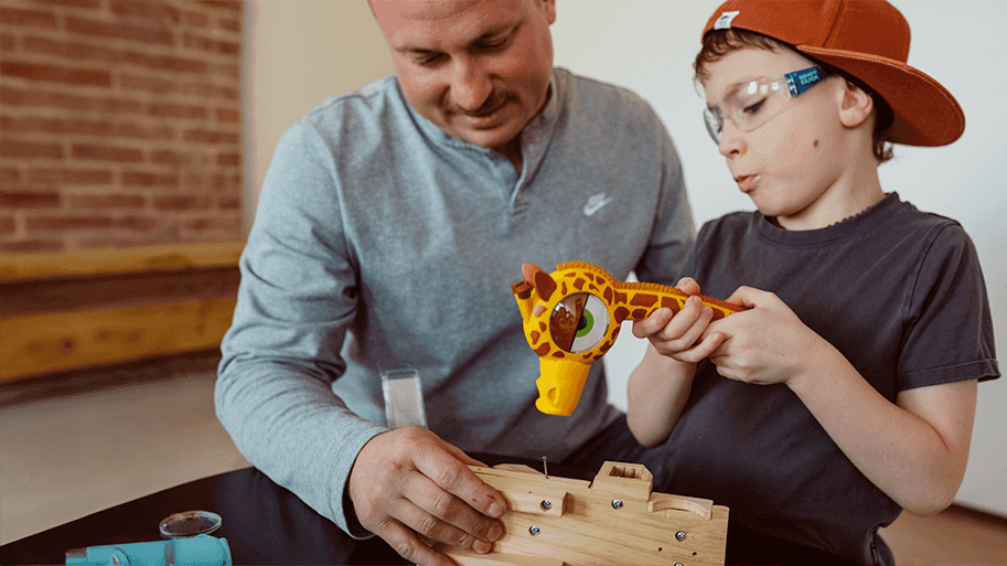 Dad and son hammering together with a HandyFamm giraffe kids hammer