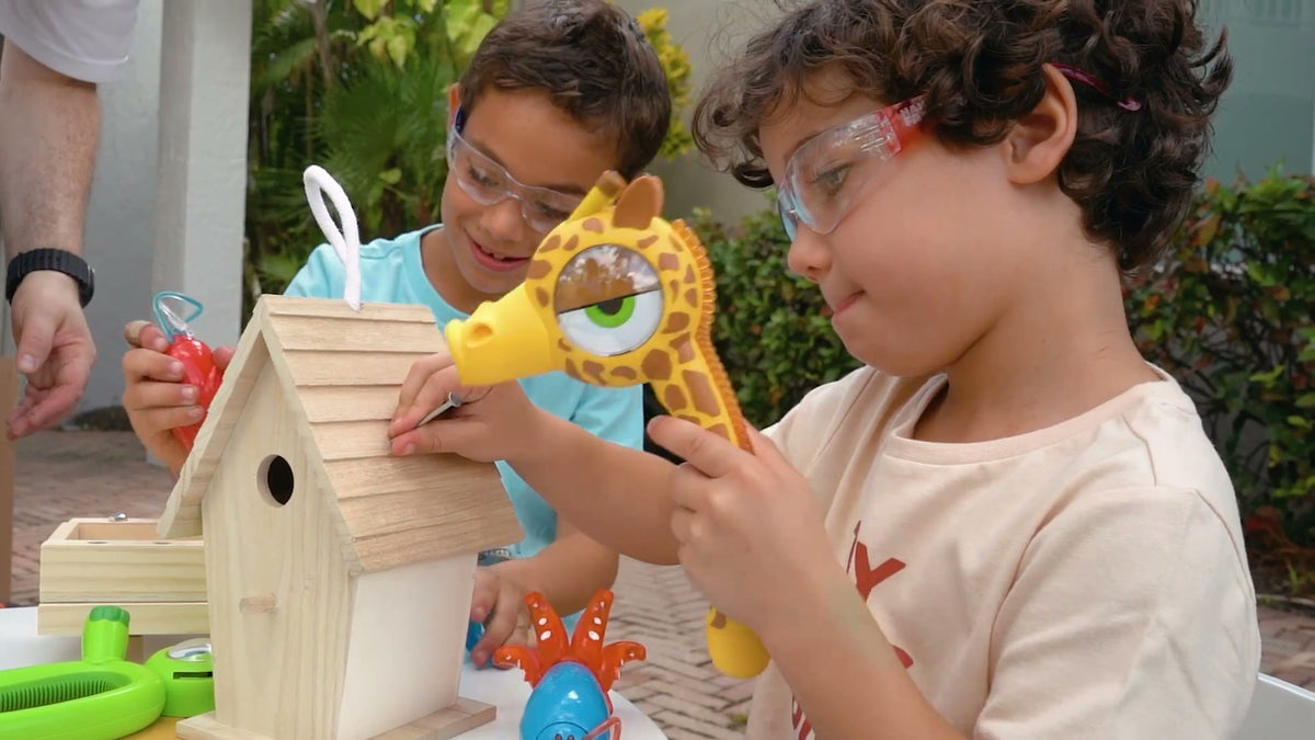 Kids in safety glasses building a birdhouse with Stretch the giraffe kids hammer